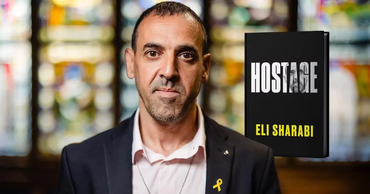 Eli Sharabi junto a la tapa de su libro, Hostage.