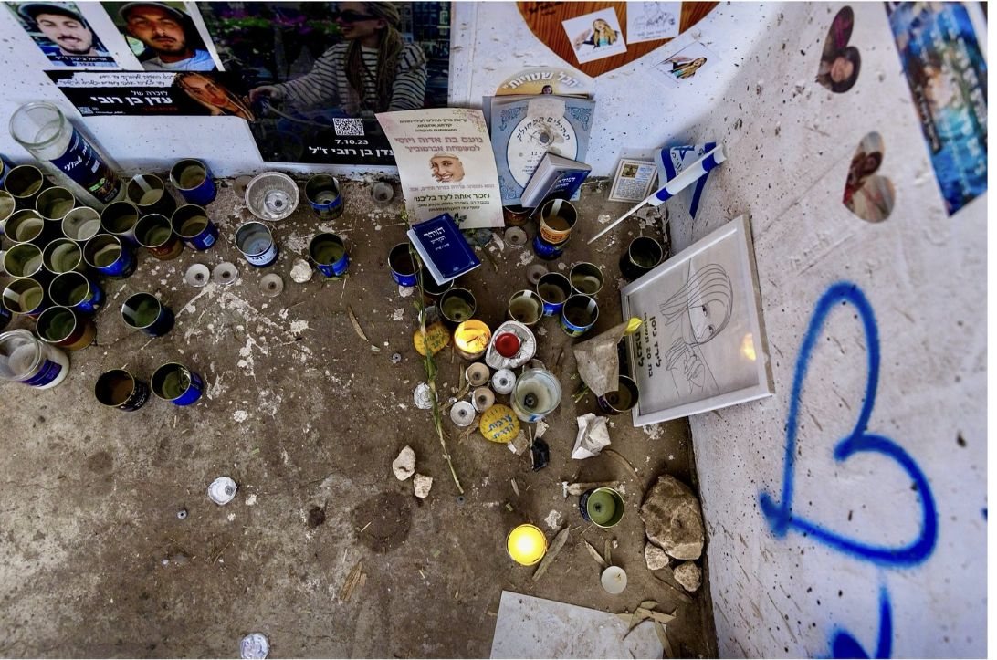 El piso del refugio con velas, libros de salmos, fotos y un corazón azul pintado en la pared.